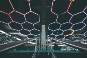 luces led 3 Explore a modern subway station with a futuristic design featuring illuminated geometric patterns and stainless steel railings.